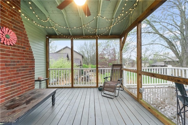 unfurnished sunroom featuring ceiling fan