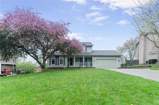 view of front of home with a porch, driveway, a front yard, a garage, and fence