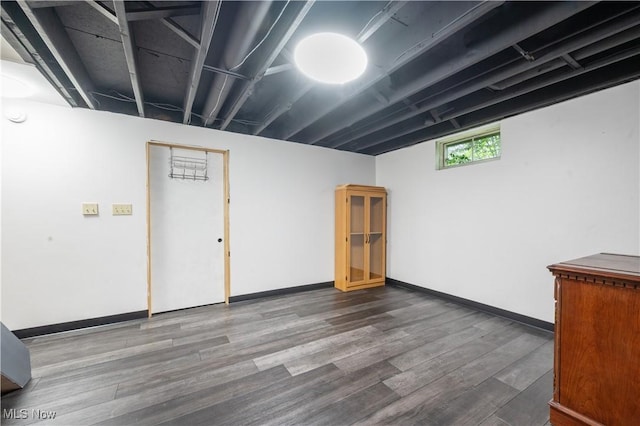 basement with baseboards and wood finished floors