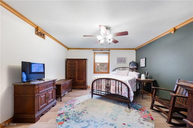 bedroom featuring baseboards, ornamental molding, light wood-style flooring, and a ceiling fan