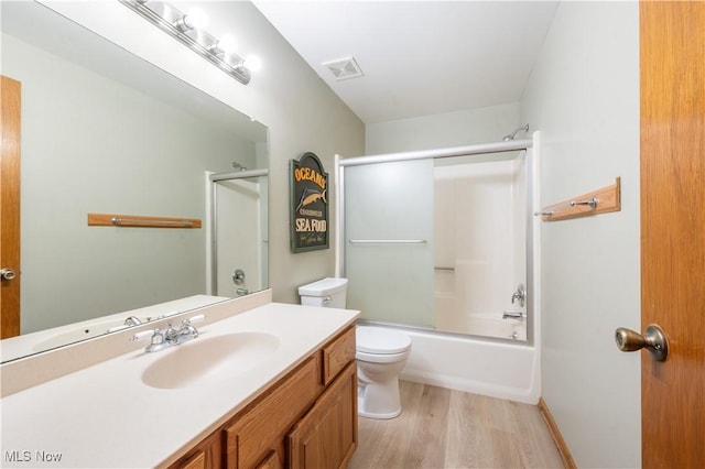 full bath with visible vents, wood finished floors, vanity, toilet, and enclosed tub / shower combo