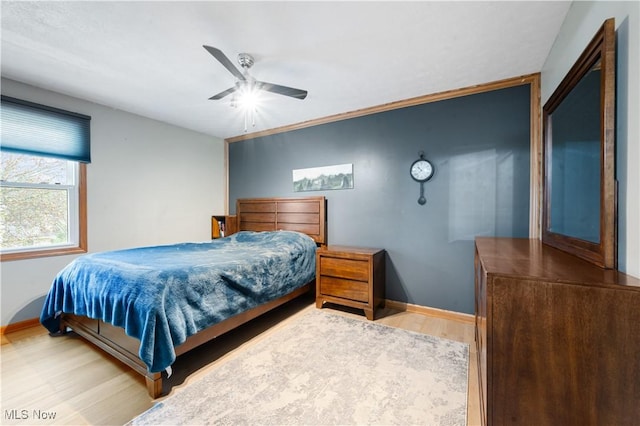 bedroom with baseboards, ceiling fan, and wood finished floors