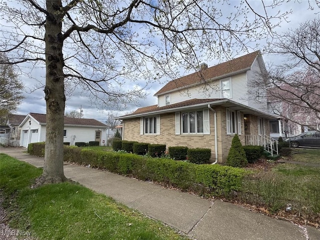 view of home's exterior with brick siding and a detached garage