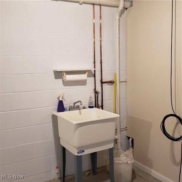 bathroom with concrete block wall and baseboards