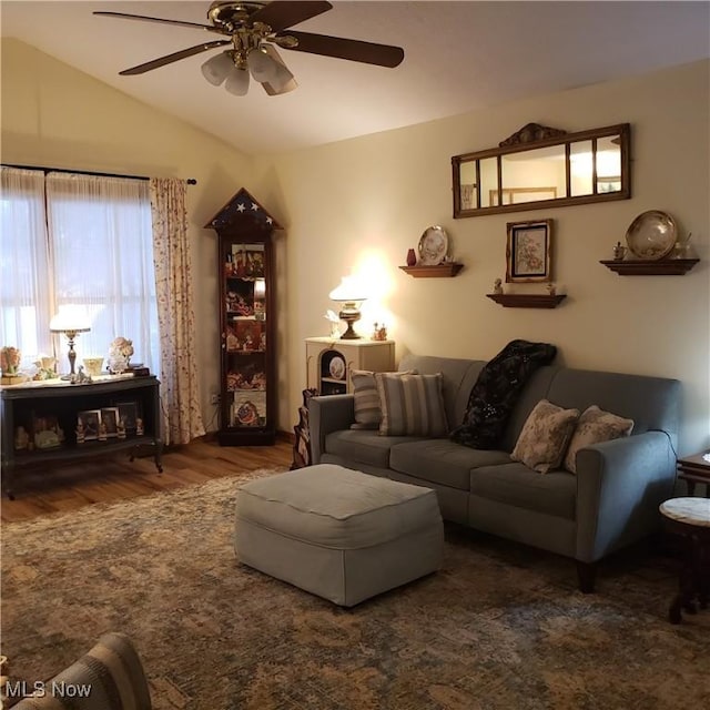 living area with wood finished floors, ceiling fan, and lofted ceiling