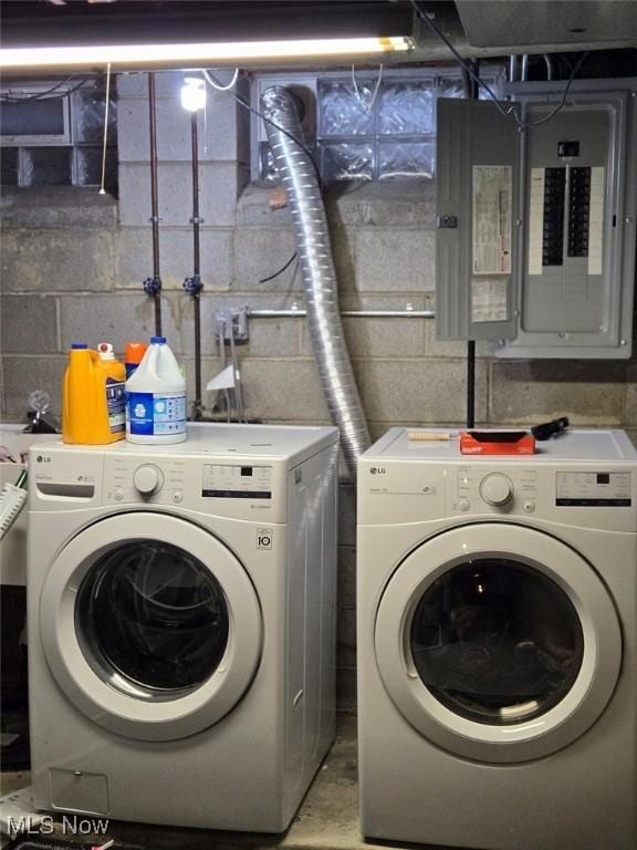 laundry room with laundry area, electric panel, and washing machine and clothes dryer