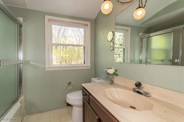 bathroom with vanity, combined bath / shower with glass door, tile patterned flooring, and toilet