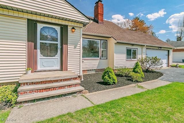 doorway to property featuring a garage, a chimney, a shingled roof, and aphalt driveway
