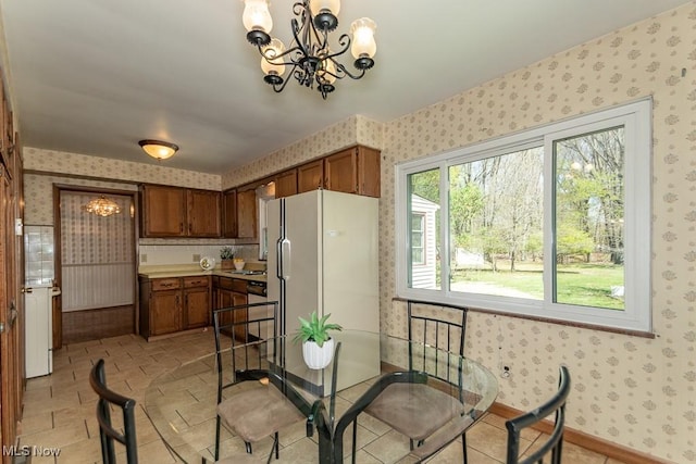 dining space with a notable chandelier and wallpapered walls