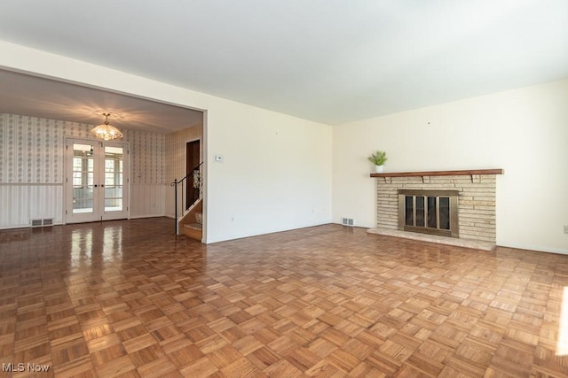 unfurnished living room with stairs, baseboards, and visible vents