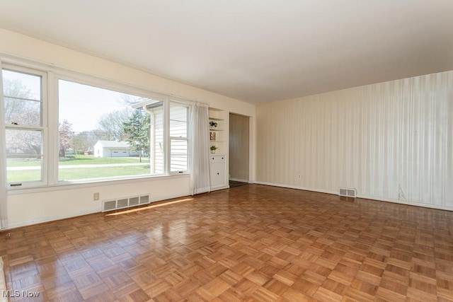 empty room featuring visible vents and baseboards