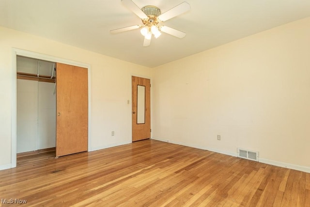unfurnished bedroom featuring visible vents, light wood-style floors, baseboards, and a closet