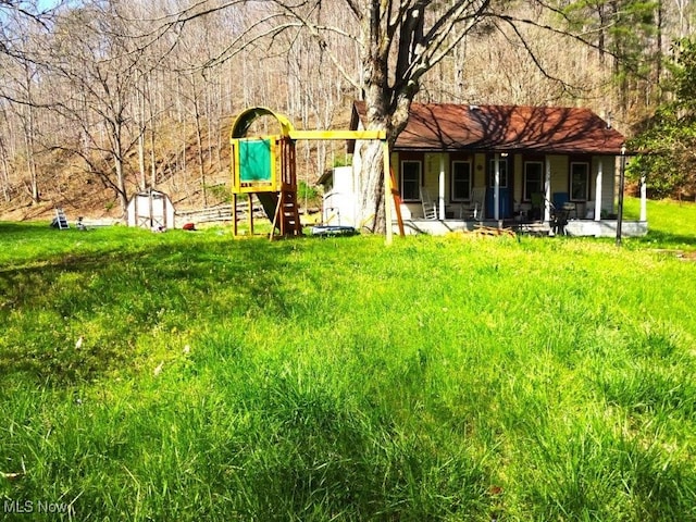 back of house featuring a storage shed and an outbuilding