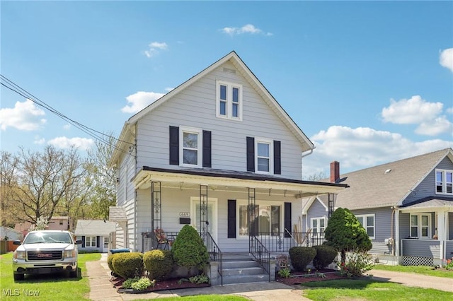 view of front of home with covered porch and a front lawn