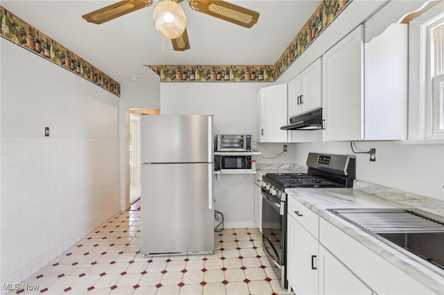 kitchen featuring ceiling fan, appliances with stainless steel finishes, white cabinets, light floors, and under cabinet range hood