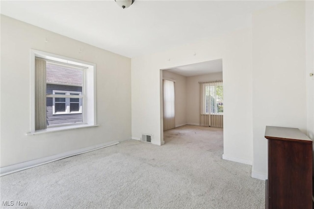 spare room featuring baseboards, visible vents, and carpet