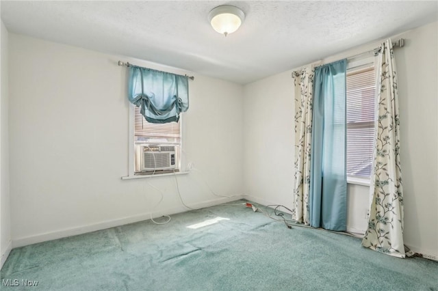 carpeted spare room featuring baseboards and cooling unit