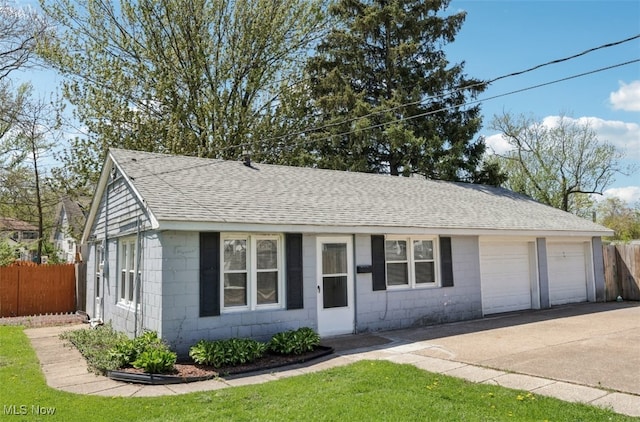 ranch-style house featuring roof with shingles, fence, driveway, and concrete block siding