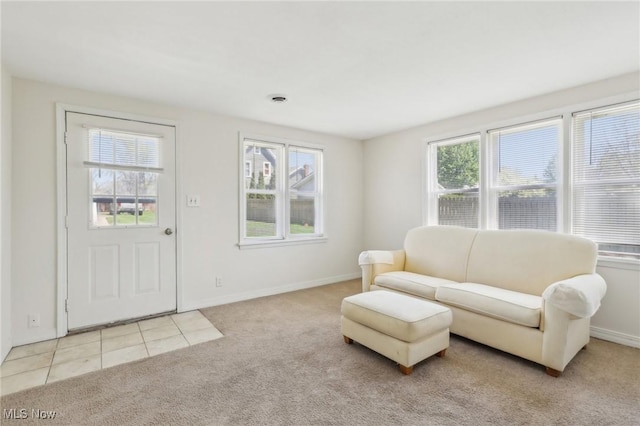 carpeted living area with baseboards and tile patterned floors
