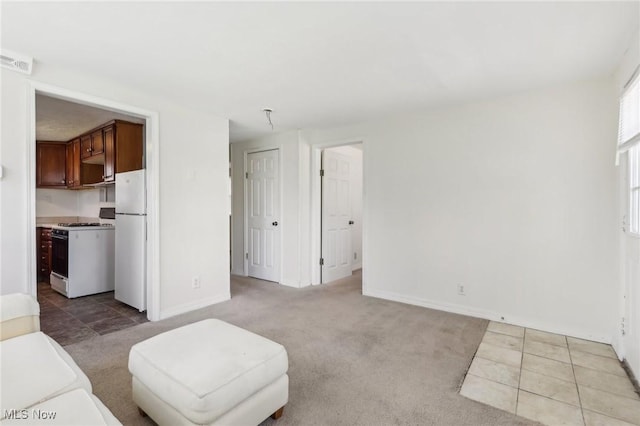 living room featuring baseboards, visible vents, and light carpet