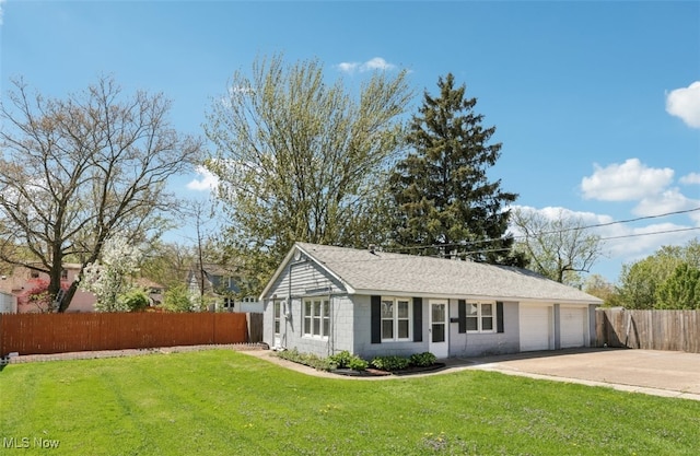 exterior space with fence, concrete driveway, a front lawn, and a garage