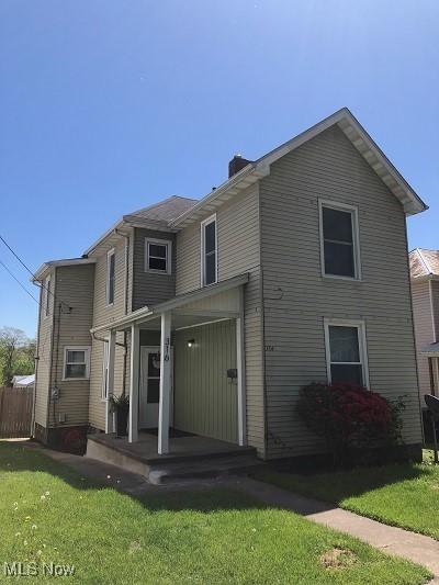 back of property with a lawn, fence, a chimney, and covered porch