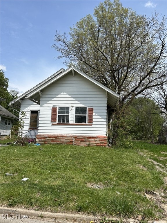 bungalow-style home with a front yard