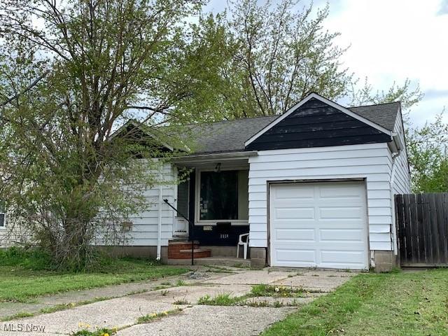 view of front facade featuring an attached garage, a shingled roof, and fence