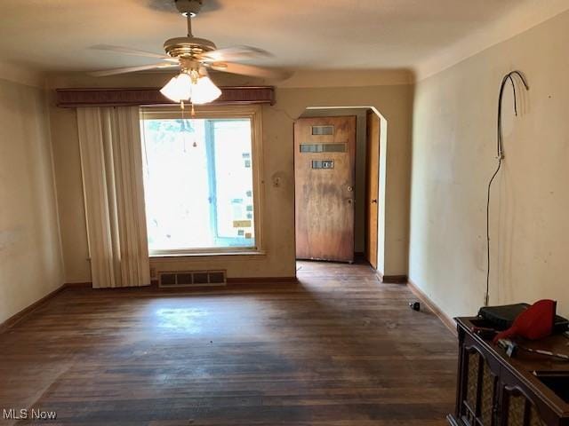 interior space featuring a ceiling fan, baseboards, visible vents, and wood finished floors