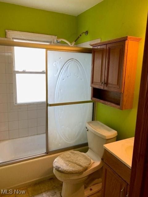 bathroom featuring vanity, toilet, and shower / bath combination with glass door