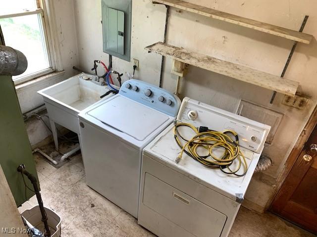 laundry area featuring separate washer and dryer, laundry area, a sink, and electric panel