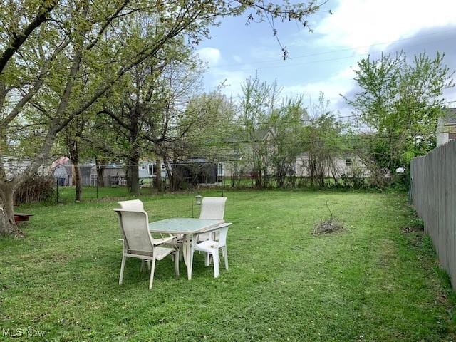 view of yard featuring outdoor dining area and a fenced backyard