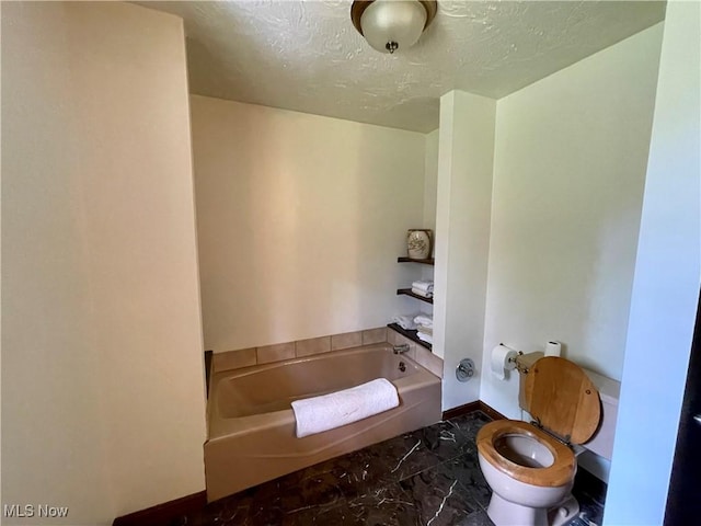 1995 Claus Rd, Vermilion, OH 44089 - bathroom featuring marble finish floor, toilet, a washtub, baseboards, and a textured ceiling