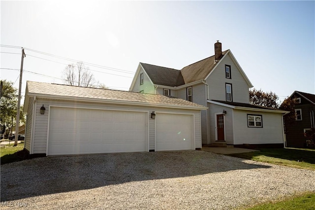 view of front of house with driveway and a chimney