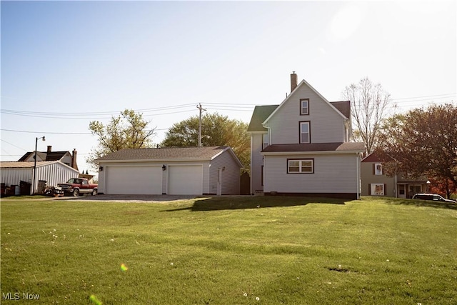 exterior space featuring a garage, an outbuilding, a chimney, and a front lawn