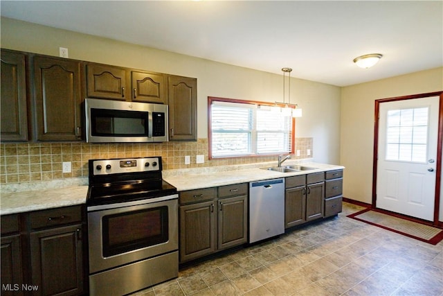 kitchen featuring plenty of natural light, a sink, appliances with stainless steel finishes, and light countertops