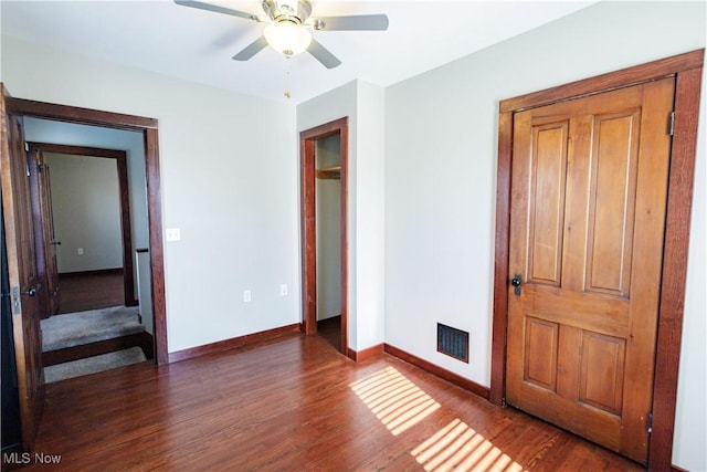 unfurnished bedroom with ceiling fan, baseboards, visible vents, and wood finished floors