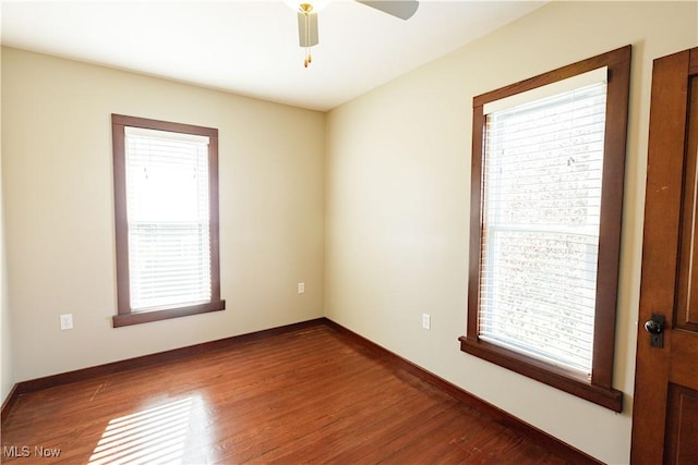 spare room with a ceiling fan, baseboards, and wood finished floors