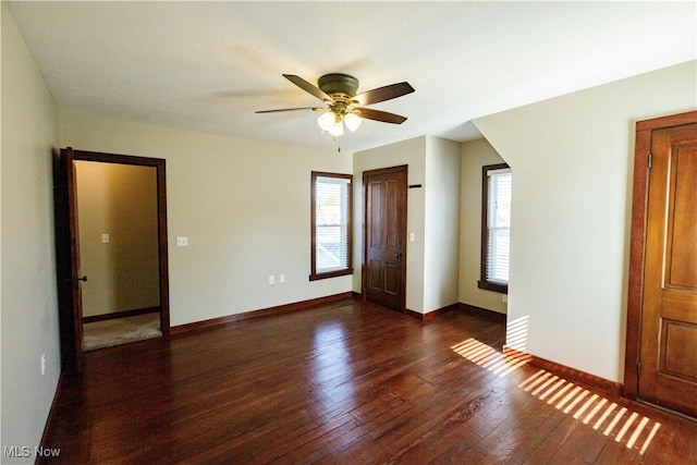 unfurnished bedroom with baseboards, wood finished floors, and multiple windows