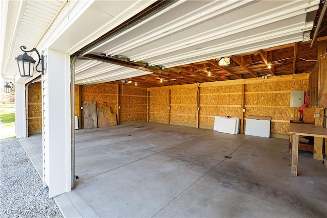 garage with a garage door opener and electric panel