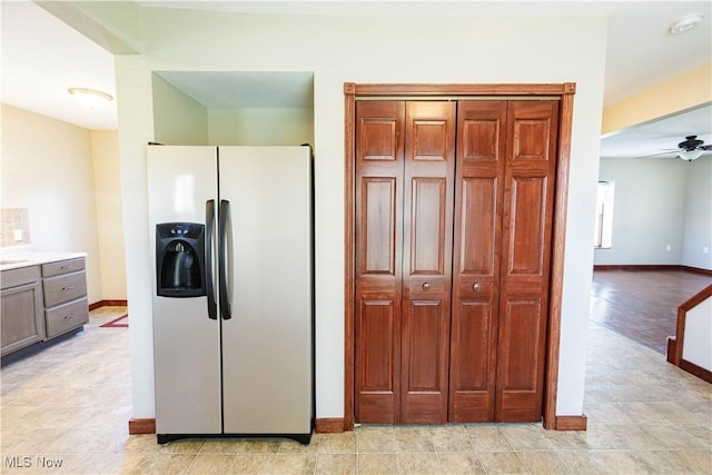kitchen featuring light countertops, fridge with ice dispenser, baseboards, and ceiling fan