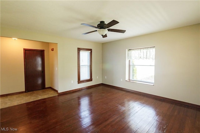 spare room featuring baseboards, a ceiling fan, and wood finished floors
