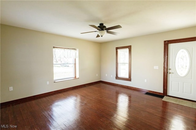 foyer with a ceiling fan, baseboards, visible vents, and wood finished floors