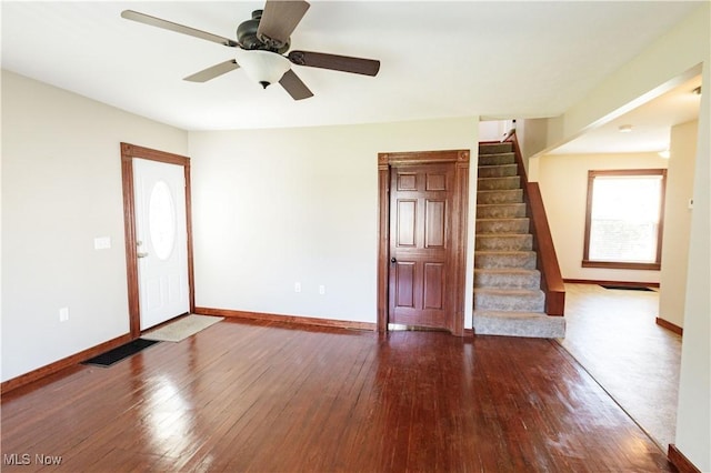 unfurnished living room featuring stairs, baseboards, visible vents, and hardwood / wood-style floors