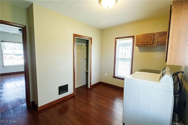washroom with visible vents, washing machine and dryer, baseboards, dark wood-style floors, and cabinet space