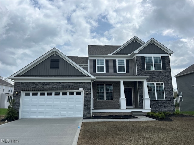 craftsman house with board and batten siding, a porch, a garage, concrete driveway, and stone siding