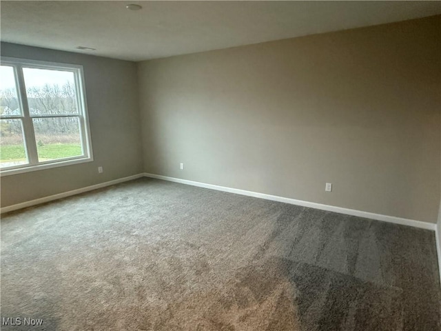 carpeted empty room featuring baseboards