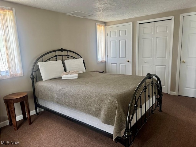 carpeted bedroom with baseboards, a textured ceiling, and multiple windows