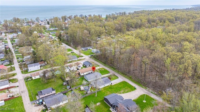 aerial view featuring a water view, a view of trees, and a residential view