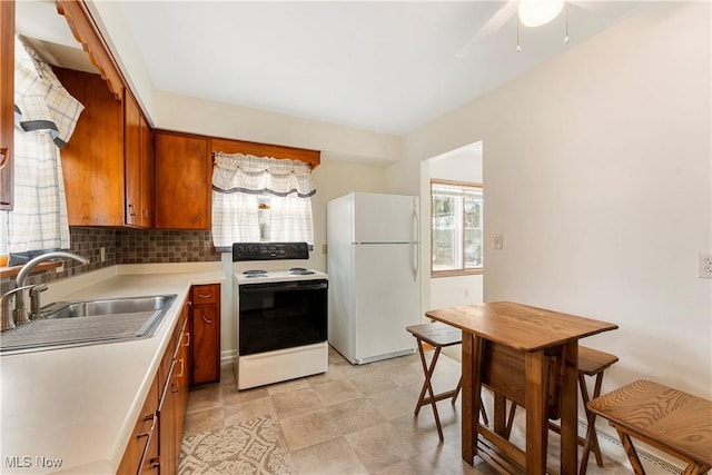 449 W Long Lake Blvd, Akron, OH 44319 - kitchen with a sink, electric range oven, light countertops, brown cabinetry, and freestanding refrigerator